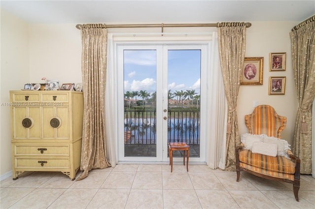 doorway featuring a water view and light tile patterned floors