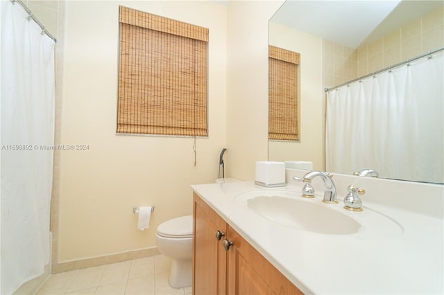 bathroom featuring toilet, vanity, tile patterned floors, and walk in shower