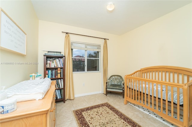 bedroom with a crib and light tile patterned floors