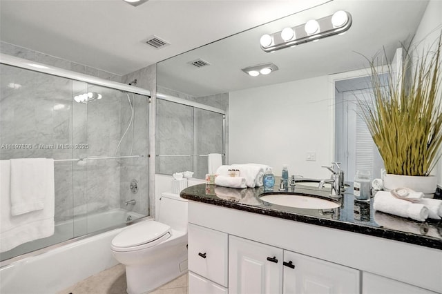 full bathroom with combined bath / shower with glass door, vanity, tile patterned flooring, and toilet