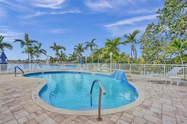 view of swimming pool with pool water feature and a patio