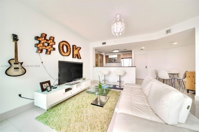 living room featuring light tile patterned floors, an inviting chandelier, and expansive windows