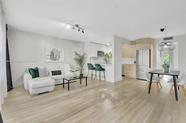 living room featuring light hardwood / wood-style flooring and rail lighting