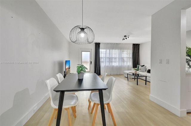 dining space featuring light hardwood / wood-style flooring and a chandelier