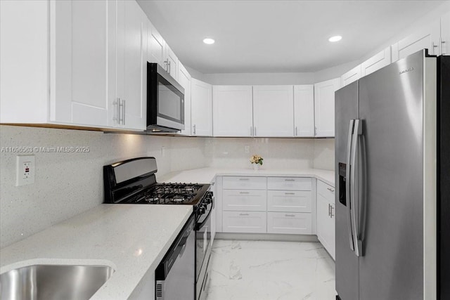 kitchen featuring backsplash, white cabinets, and stainless steel appliances