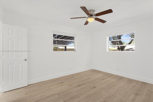 spare room featuring light hardwood / wood-style floors, a wealth of natural light, and ceiling fan