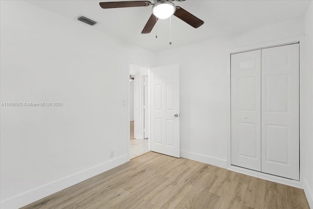 unfurnished bedroom with a closet, light hardwood / wood-style flooring, and ceiling fan