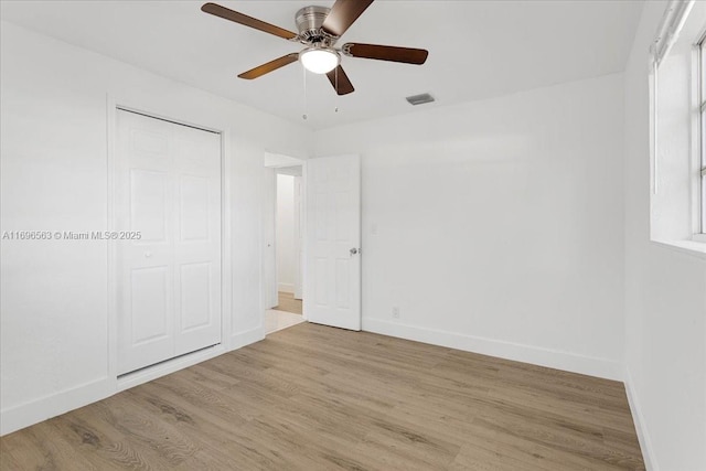 unfurnished bedroom with ceiling fan, light hardwood / wood-style flooring, and a closet