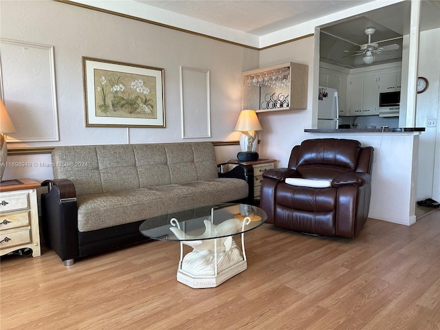 living room featuring ceiling fan and light hardwood / wood-style flooring