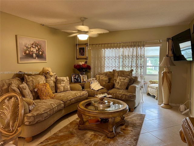 living room featuring ceiling fan, light tile patterned flooring, and a textured ceiling