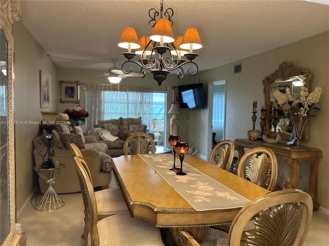 tiled dining space with ceiling fan with notable chandelier