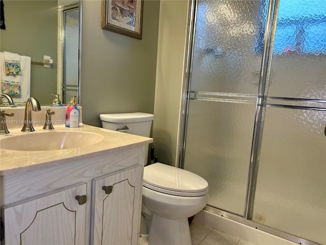 bathroom with tile patterned flooring, vanity, toilet, and walk in shower