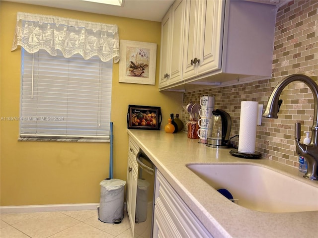 clothes washing area featuring light tile patterned floors and sink