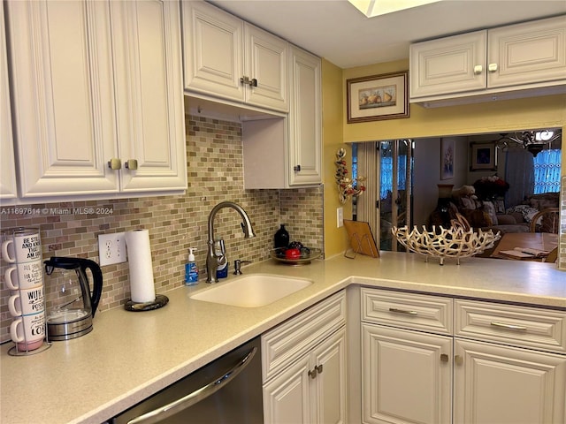 kitchen featuring backsplash, dishwasher, sink, and white cabinets