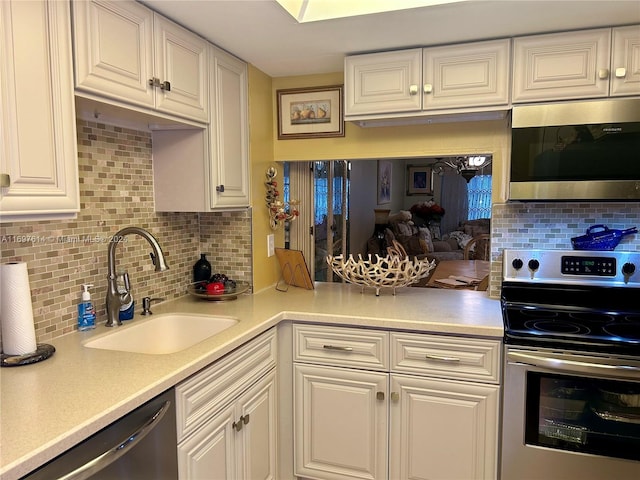 kitchen with white cabinets, backsplash, stainless steel appliances, and sink