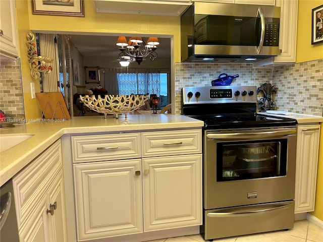 kitchen with tasteful backsplash, light tile patterned flooring, stainless steel appliances, and a notable chandelier