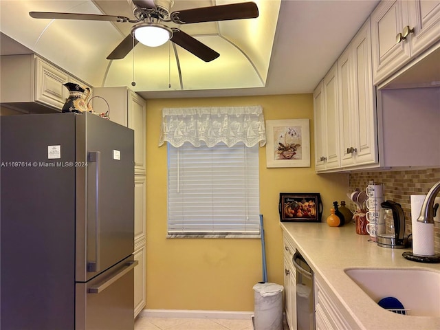 kitchen with appliances with stainless steel finishes, backsplash, ceiling fan, sink, and white cabinetry