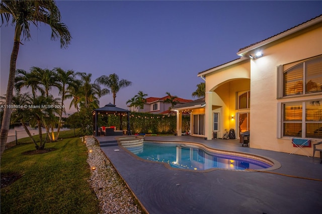 pool at dusk with a gazebo, a yard, and a patio