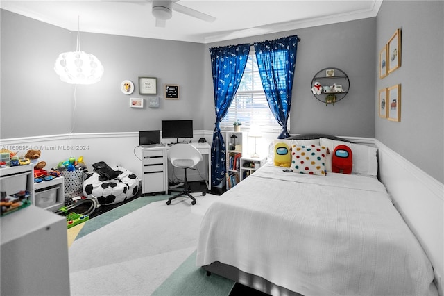 carpeted bedroom featuring ceiling fan and crown molding