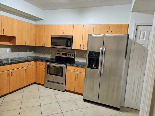 kitchen featuring sink, appliances with stainless steel finishes, light tile patterned flooring, and decorative backsplash