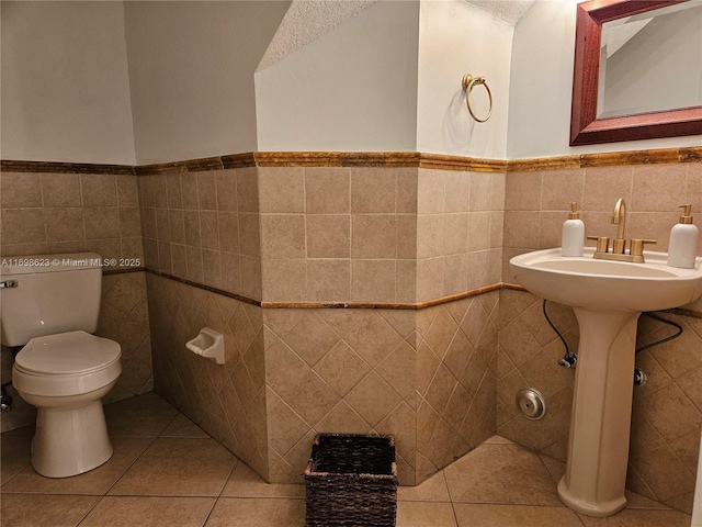 bathroom featuring tile walls, a textured ceiling, tile patterned floors, and toilet