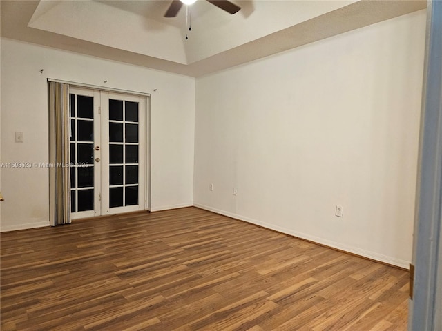 spare room featuring ceiling fan, french doors, a tray ceiling, and wood-type flooring