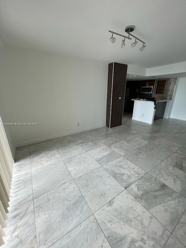 unfurnished living room with track lighting