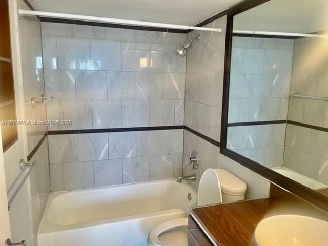 full bathroom featuring vanity, tiled shower / bath combo, and toilet