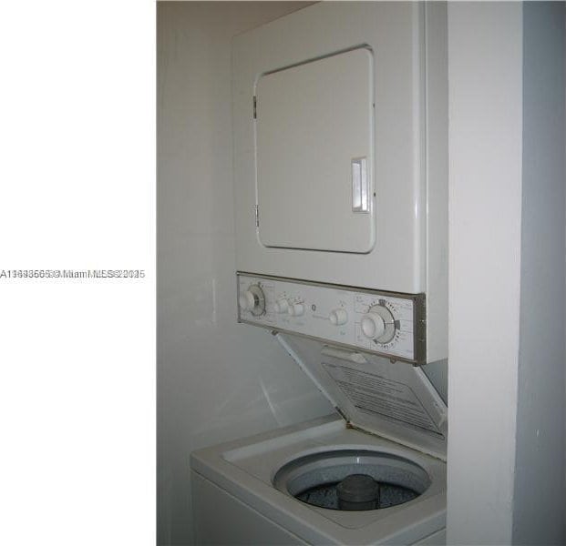 laundry room featuring stacked washer / drying machine