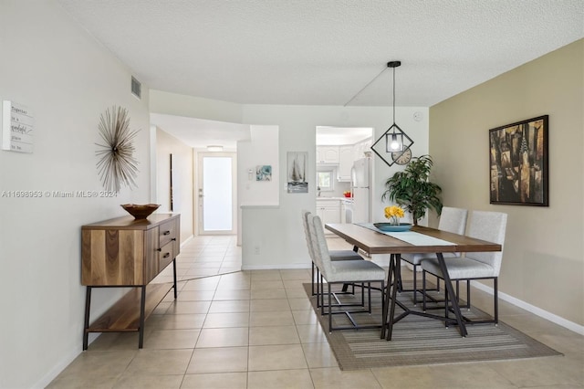 tiled dining space with a textured ceiling