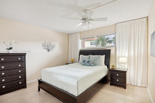 tiled bedroom featuring ceiling fan and a textured ceiling