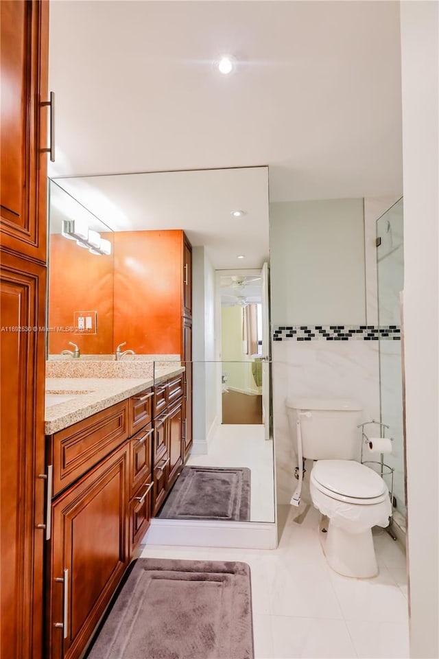 bathroom featuring tile patterned flooring, vanity, toilet, and walk in shower