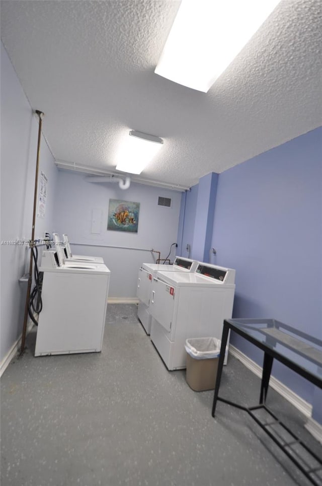 clothes washing area featuring a textured ceiling and independent washer and dryer