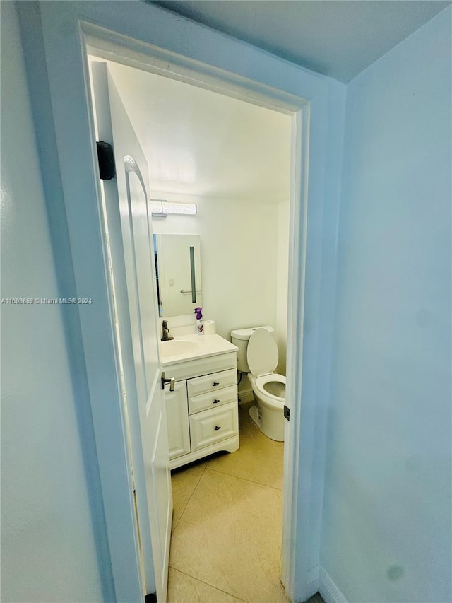 bathroom with tile patterned flooring, vanity, and toilet