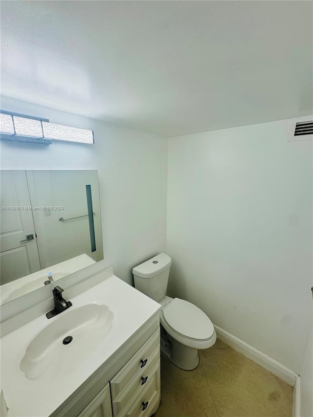 bathroom featuring tile patterned flooring, vanity, and toilet