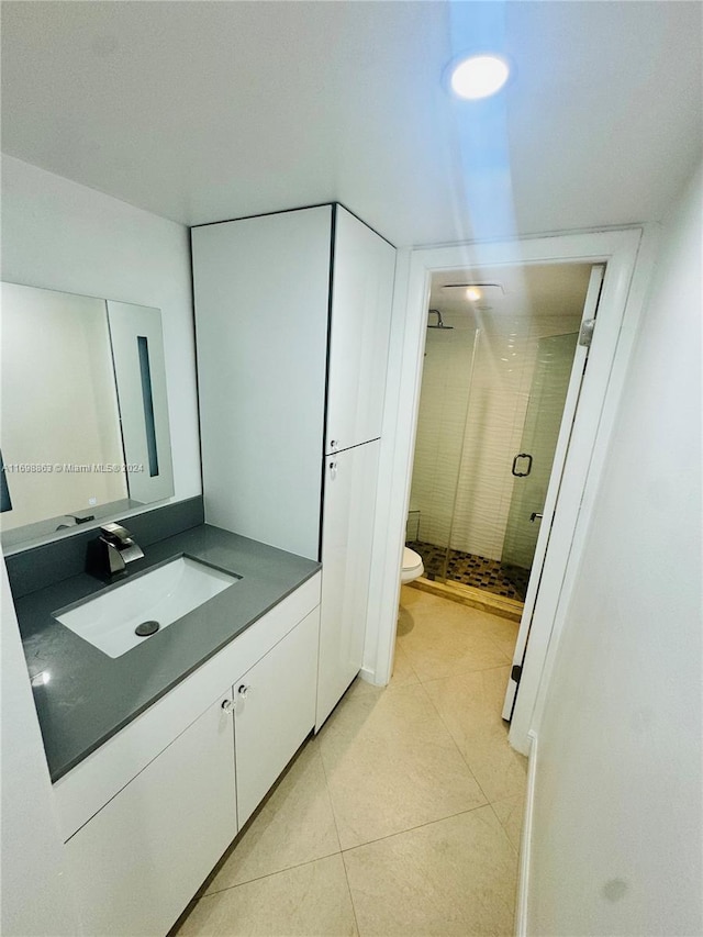 bathroom featuring tile patterned floors, vanity, toilet, and an enclosed shower