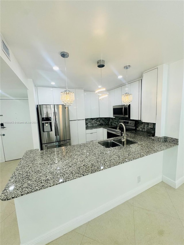 kitchen with kitchen peninsula, hanging light fixtures, and stainless steel appliances