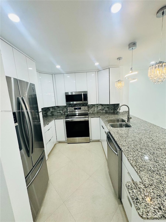 kitchen featuring white cabinetry, hanging light fixtures, stainless steel appliances, and sink