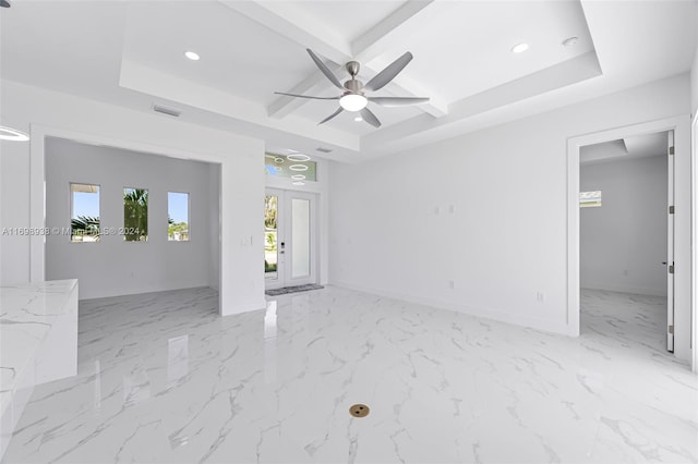 empty room featuring a tray ceiling and ceiling fan