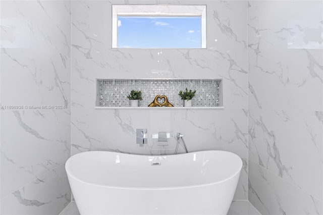 bathroom featuring a bath and tile walls