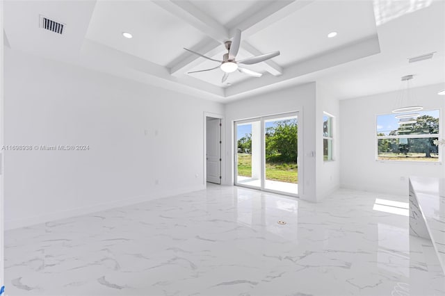 empty room featuring beamed ceiling, ceiling fan, and a raised ceiling