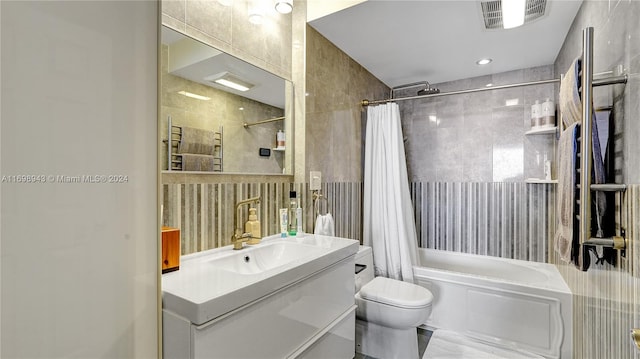 full bathroom featuring shower / bath combination with curtain, toilet, tile walls, and vanity