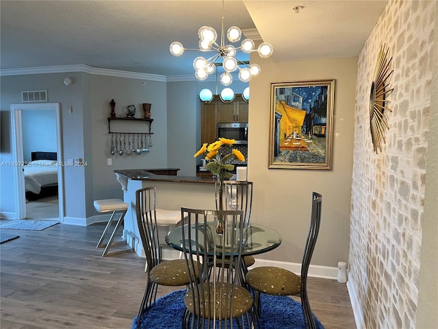 dining room featuring a notable chandelier, dark hardwood / wood-style floors, and ornamental molding