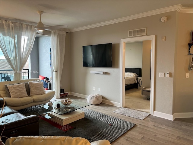 living room with hardwood / wood-style floors, ceiling fan, and crown molding