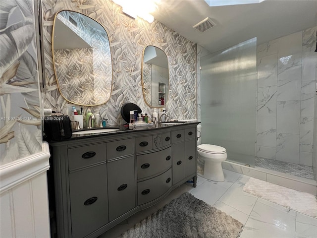 bathroom featuring a tile shower, vanity, and toilet