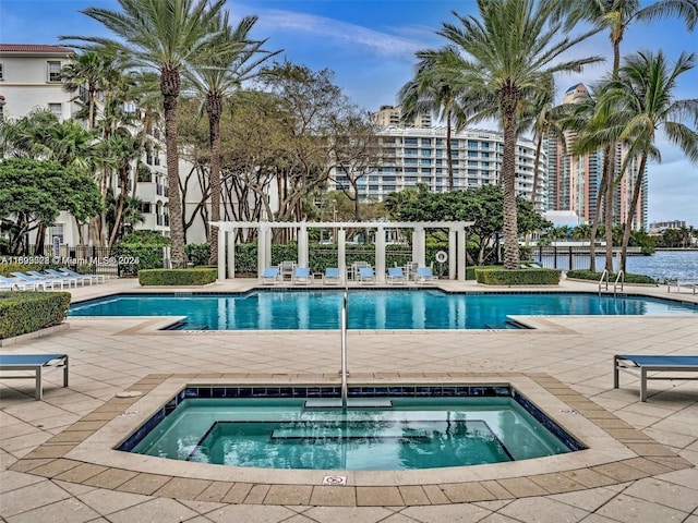 view of pool with a patio area and a hot tub