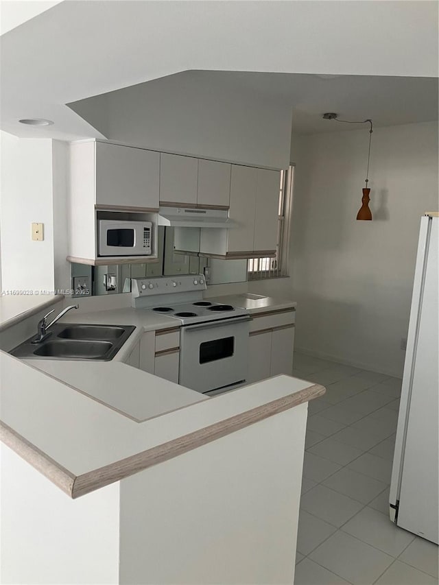 kitchen with sink, light tile patterned floors, white appliances, and kitchen peninsula