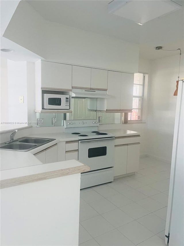 kitchen featuring white cabinetry, sink, white appliances, and kitchen peninsula