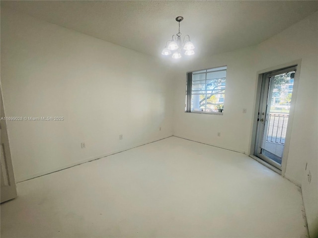 unfurnished room featuring a chandelier