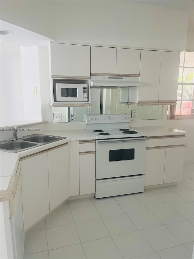 kitchen featuring white cabinetry, sink, and white appliances